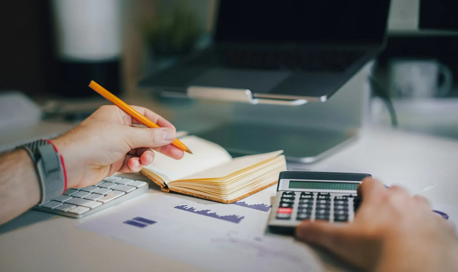 Accounts being worked out by hand with a notebook, calculator and receipts